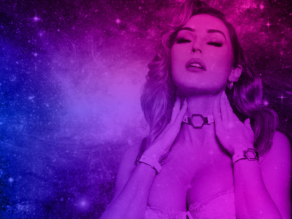 Glamour portrait of a woman in pink and blue cosmic lighting with a sparkling galaxy backdrop