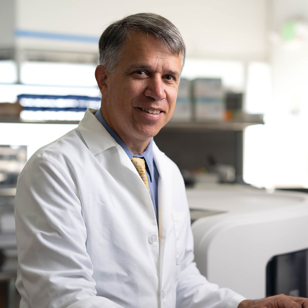 Dr Andreas K wearing a lab coat in a laboratory
